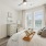 Bedroom with bed, dresser, and large windows