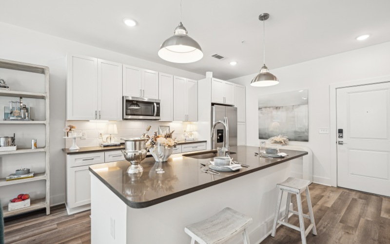 Chef inspired kitchen with gray cabinetry, stainless steel appliances and large island with bar seating